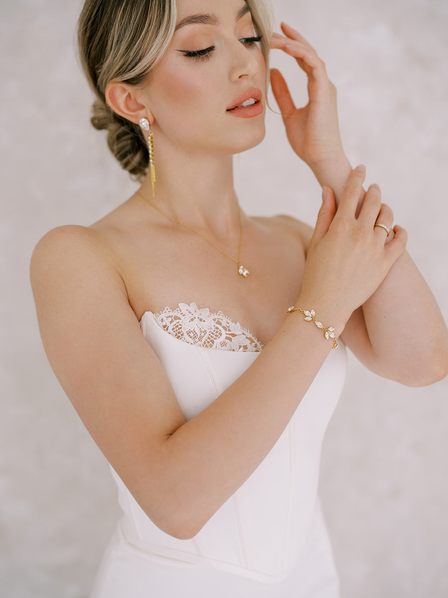 Bride wearing matching bridal jewelry set consisting of earrings, bracelet and crystal necklace by Joanna Bisley Designs.