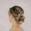 Bride with updo wearing two blush and floral hairpins