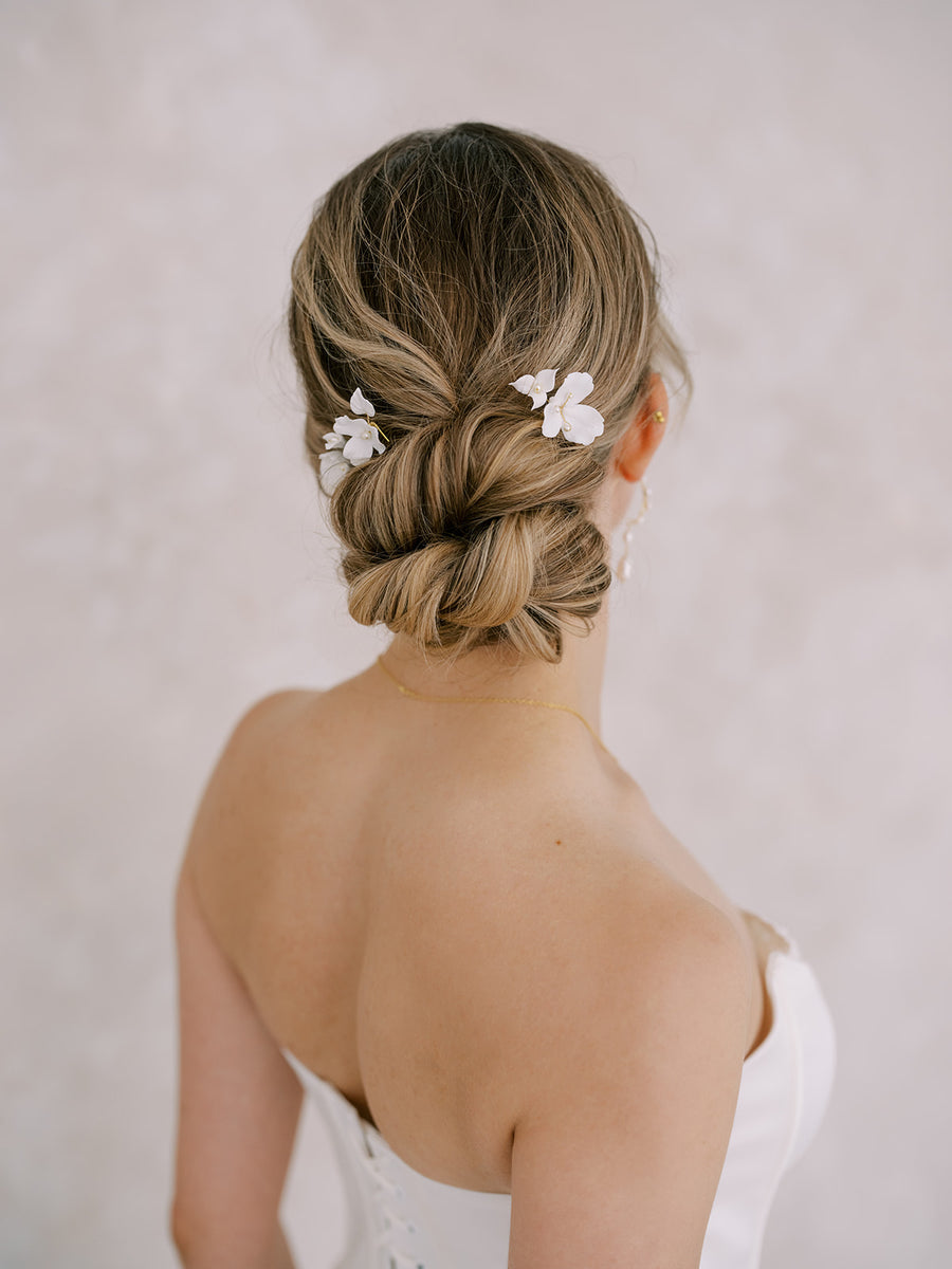 The back of a bride's updo with two flower bridal hairpins in it handcrafted by Joanna Bisley Designs.