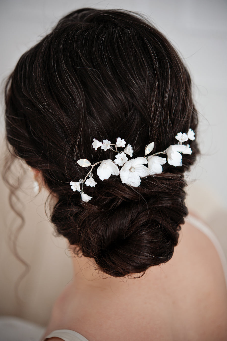 Bride with a romantic bridal bun wearing an exquisite white opal bridal comb.