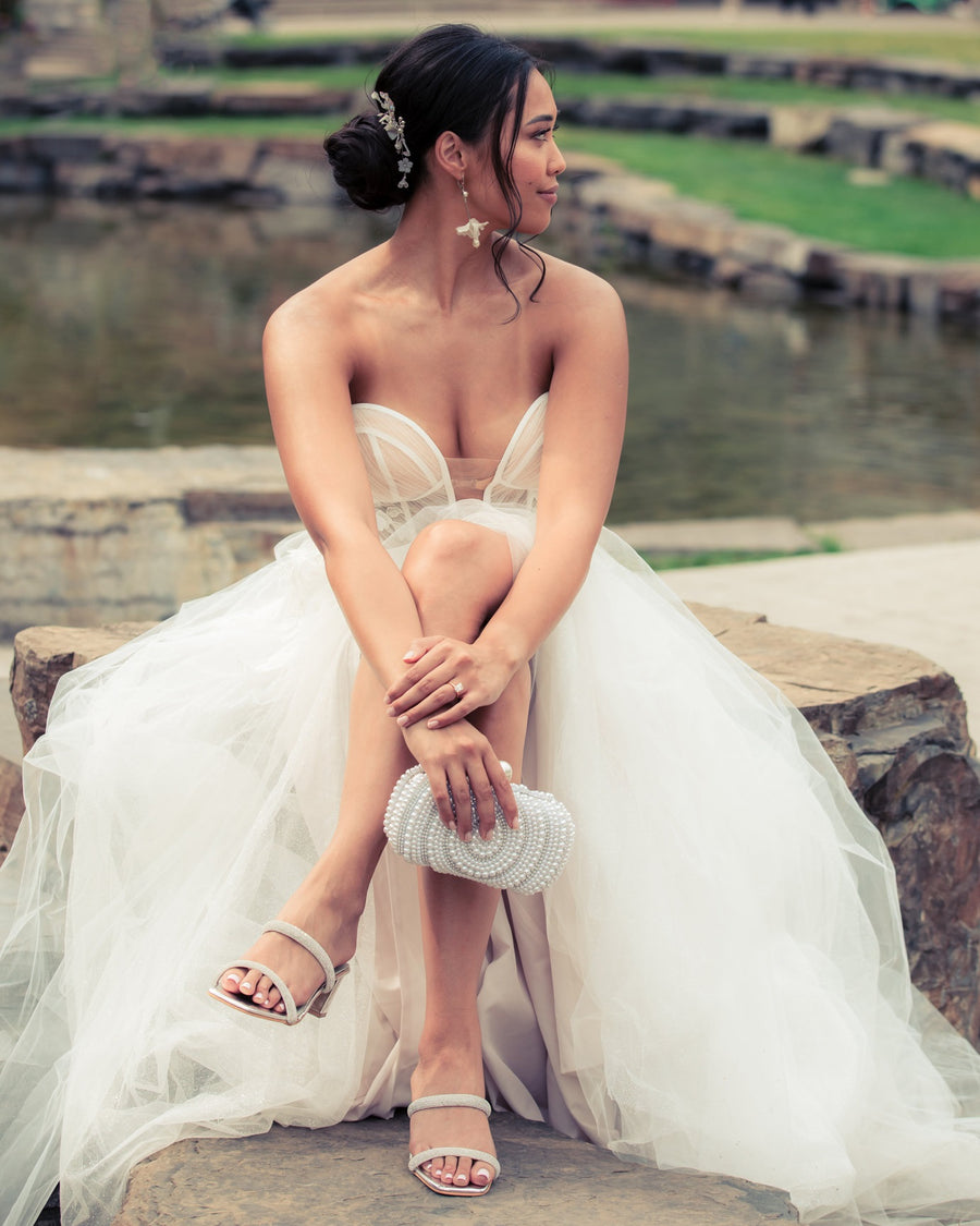 Bride wearing coordinating bridal comb and flower wedding earrings.