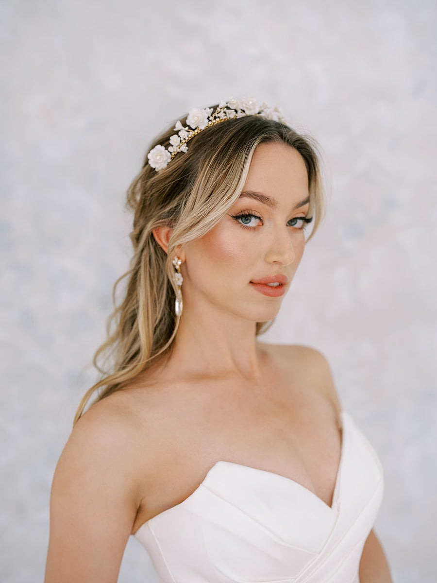 Bride with hair down wearing a flower bridal crown and drop earrings.