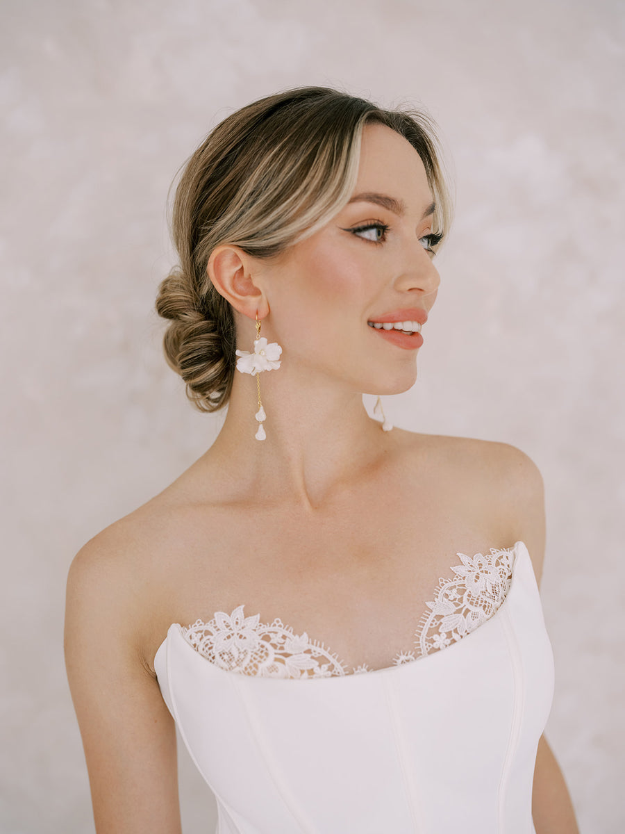 Bride with strapless bridal gown wearing statement flower bridal earrings.