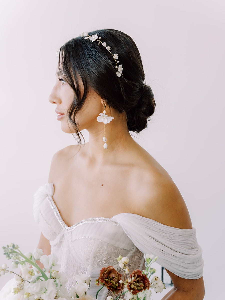 Bride wearing flower hair vine and flower statement bridal earrings.