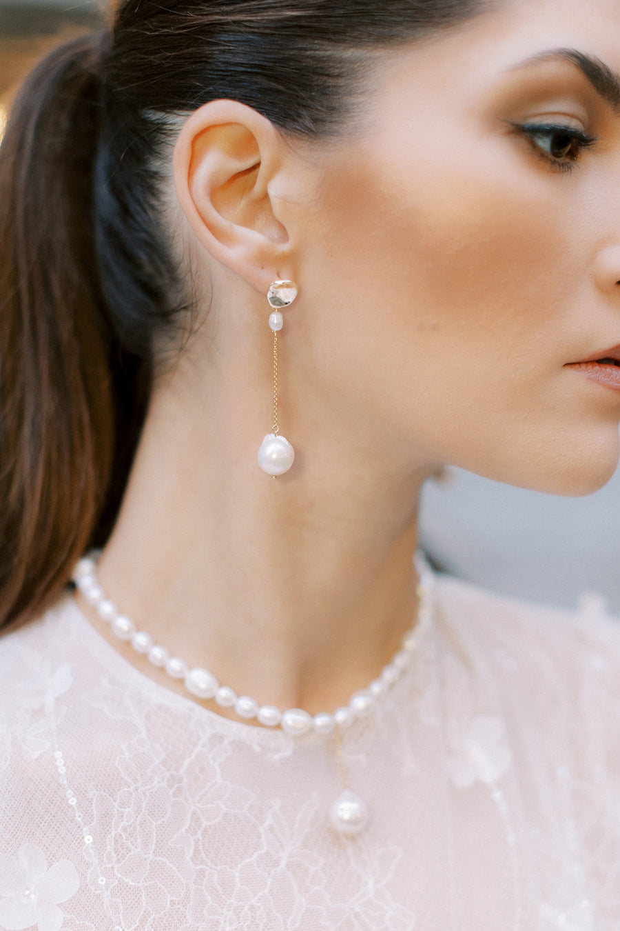 Bride wearing freshwater pearl bridal necklace and long pearl wedding earrings. 