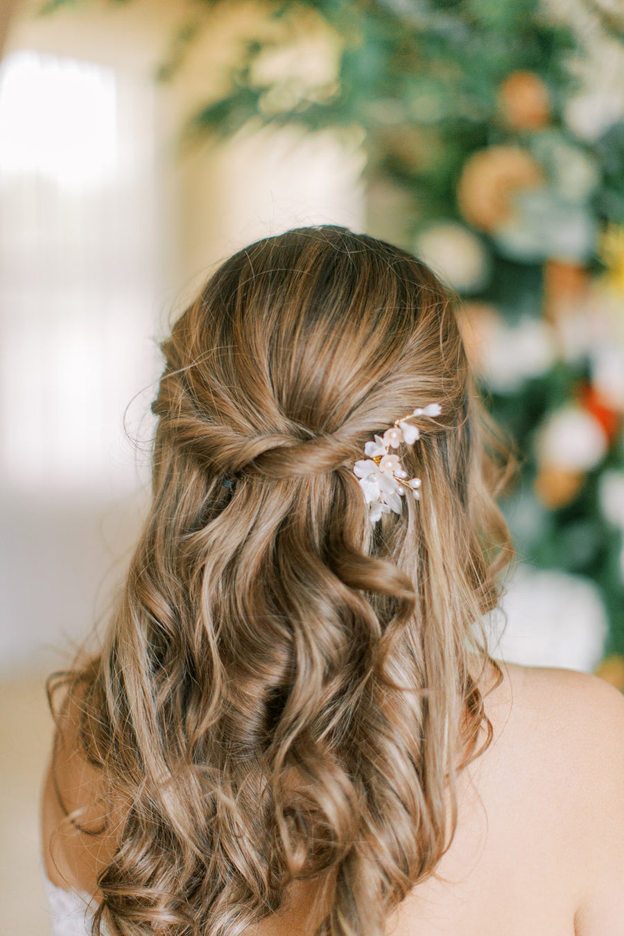 Bride with half up half down wedding hairstyle wearing a flower and pearl bridal comb by Joanna Bisley Designs.