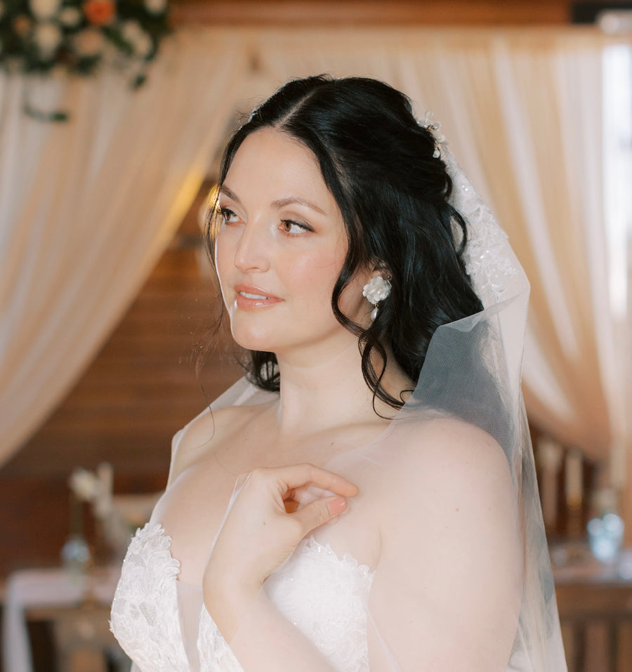 Bride wearing baroque pearl bridal earrings with a veil