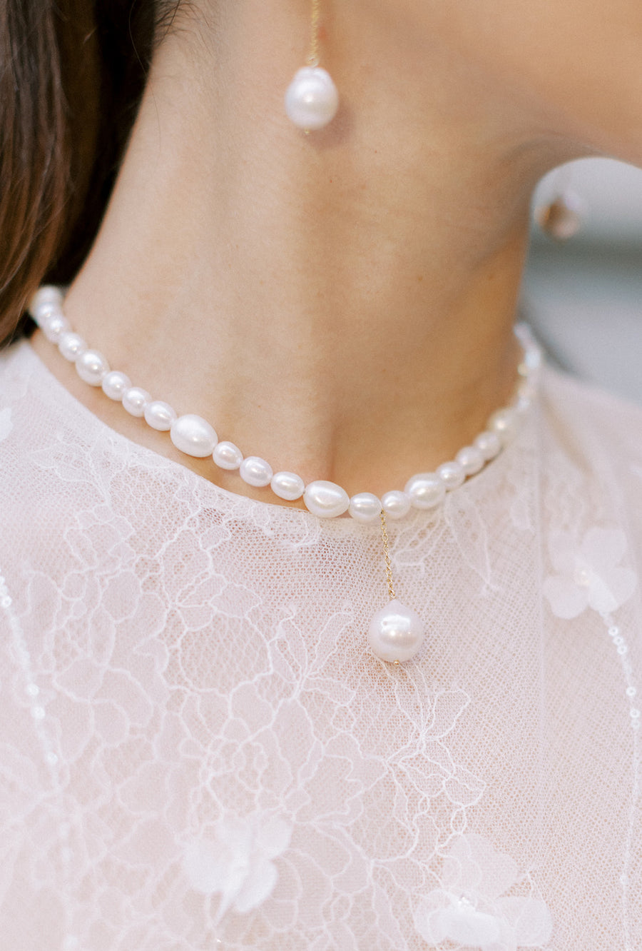 Closeup of bride's neck wearing freswater pearl necklace.