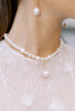 Closeup of bride's neck wearing freswater pearl necklace.