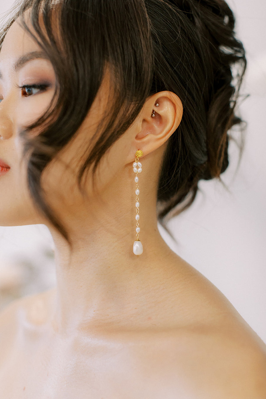 Close up of bride wearing long pearl wedding earrings by Joanna Bisley Designs.