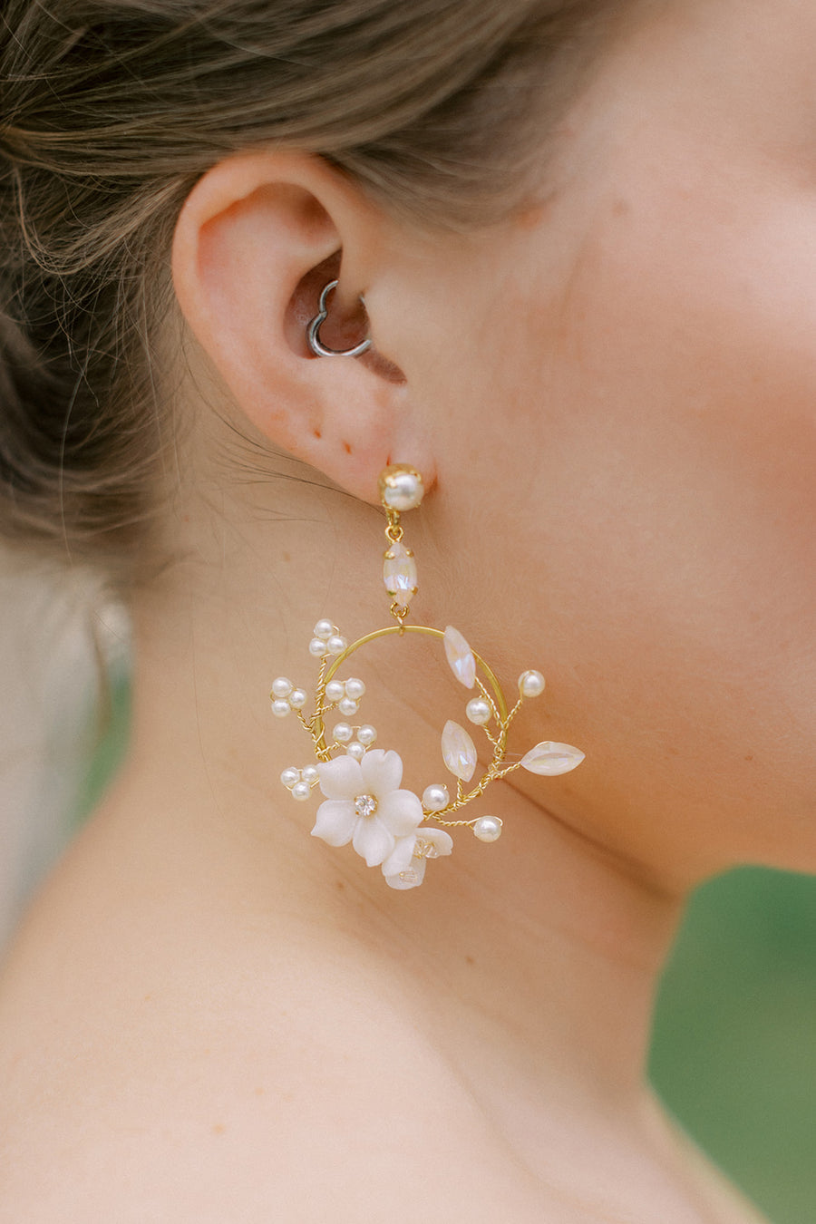 A close up of bride wearing delicate flower bridal earrings with Swarovski Crystal and pearls by Joanna Bisley Designs.