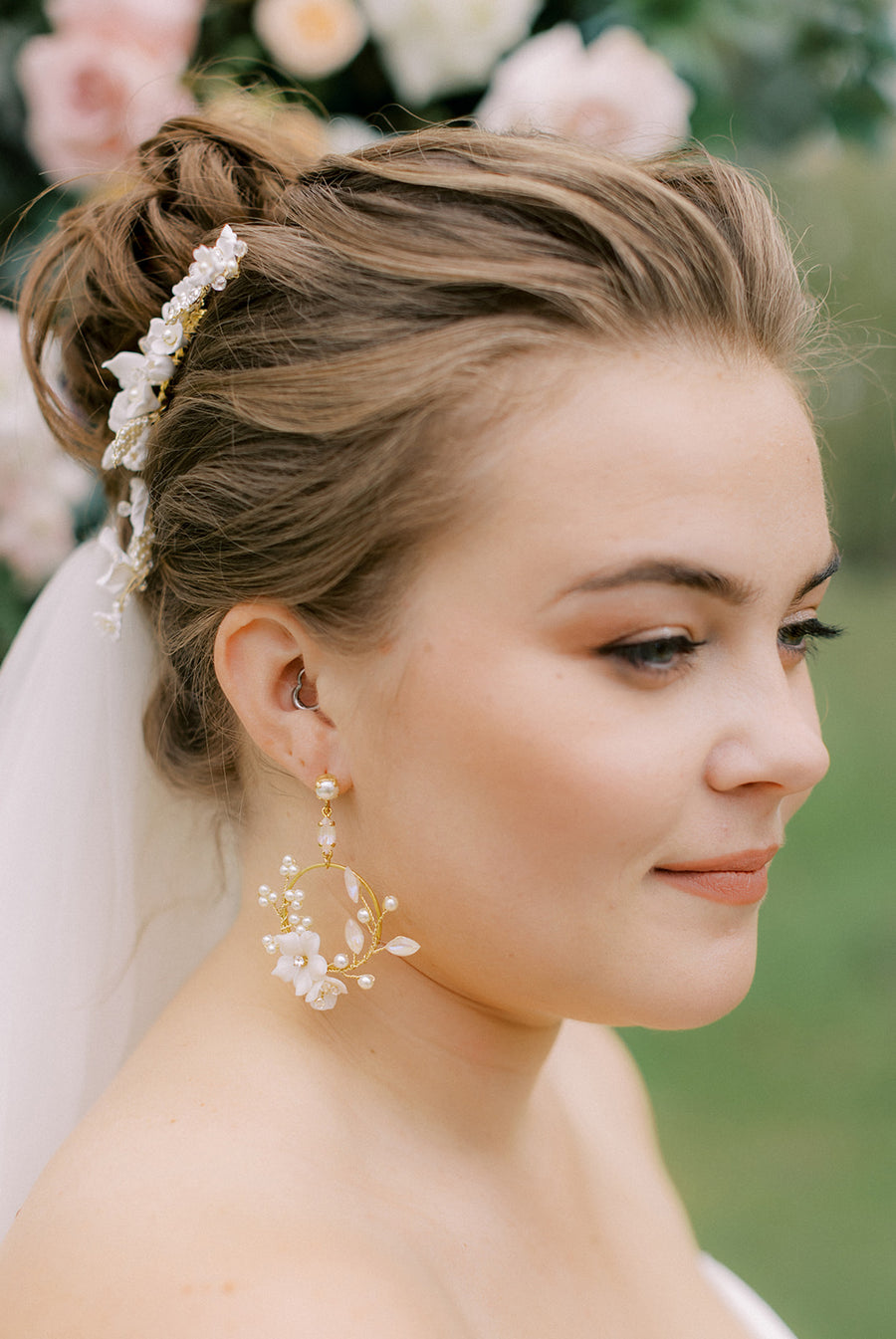 Bride wearing hoop bridal earrings with crystal and floral detailing.