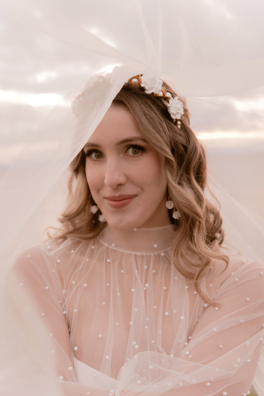 Bride with flowing veil wearing a unique bridal flower crown by Joanna Bisley Designs.