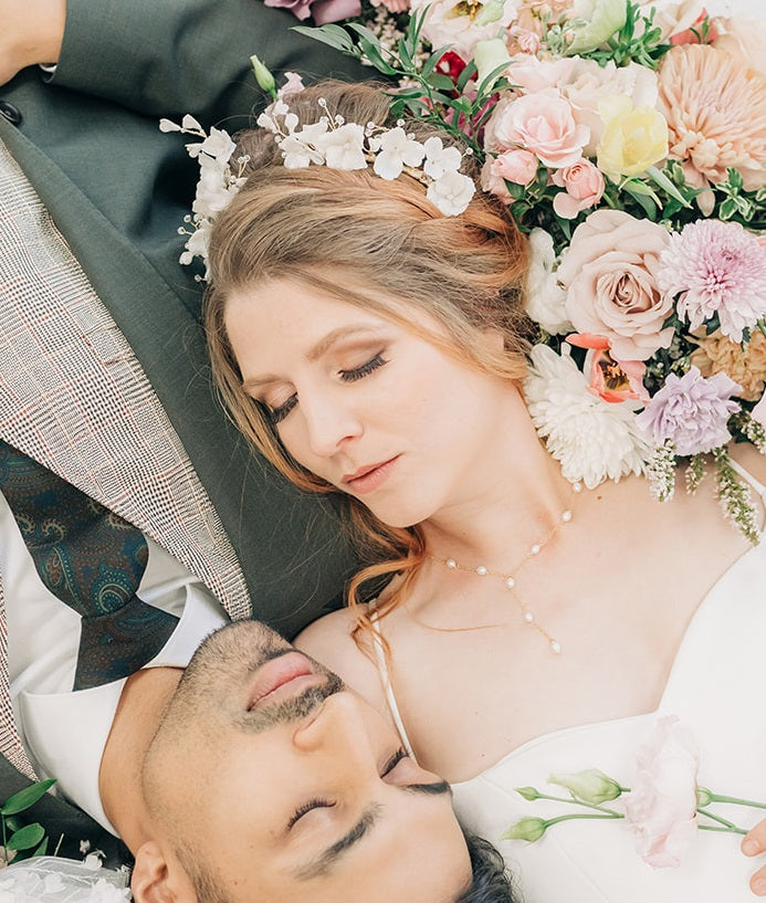 Bride reclining wearing unique bridal hair accessory and freshwater pearl necklace by Joanna Bisley Designs.