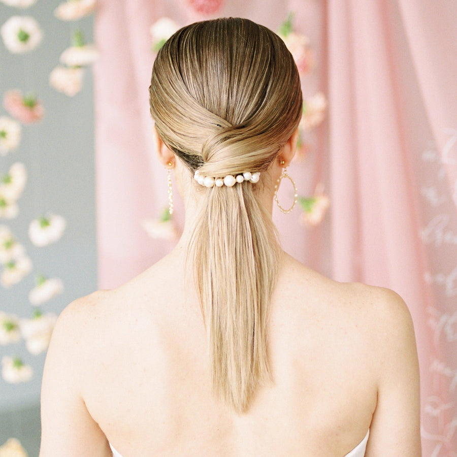 Bride wearing an exquisite pearl comb with her bridal ponytail.